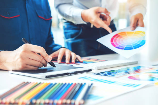 istock Two Graphic designer drawing on graphics tablet and color palette guide at workplace 1021040364