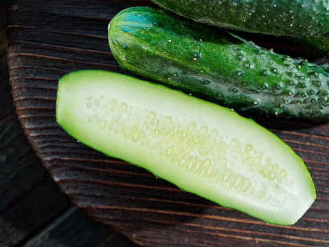 Fresh cucumbers on wooden cutting board. Close-up