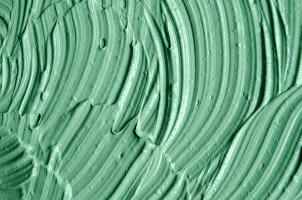 istock Green cosmetic clay (facial mask, cream, body scrub) texture close up, selective focus. Abstract background with brush strokes. 1021041096