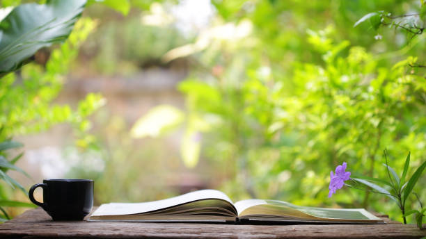 istock Black coffee cup with flower and notebook on wooden table 1021059078