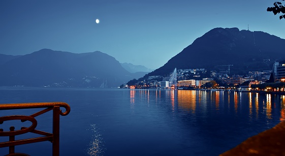 View of Lake Lugano with fountain in Lavena Ponte Tresa, Switzerland night