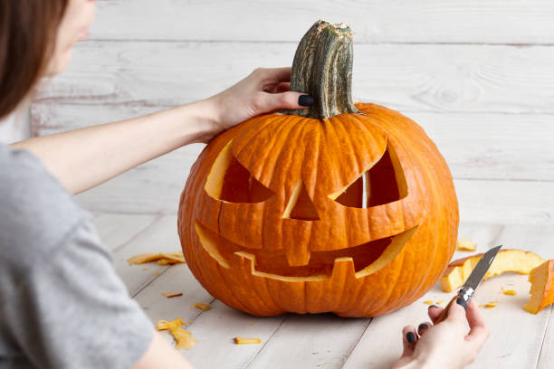 istock Carving halloween pumpkin into jack-o-lantern, close up view 1021092676