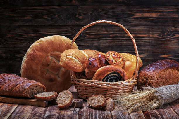 istock Ciabatta, lavash, buns and other bakery products lie on a wooden rustic table on a dark background 1021096402