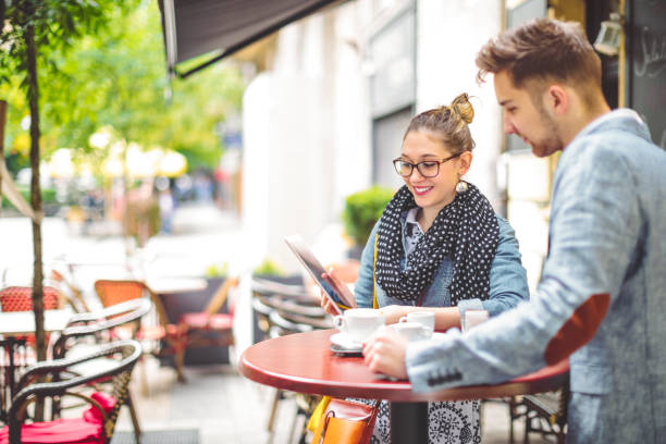 istock Friends are sharing a tablet in a sidewalk cafe 1021097058