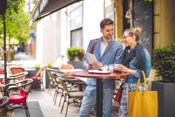 istock Friends are sharing a tablet in a sidewalk cafe 1021098056