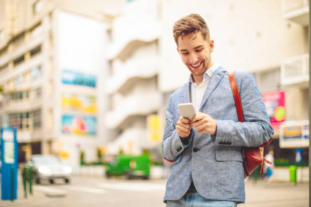 istock Young man is texting on his smartphone downtown city 1021099160