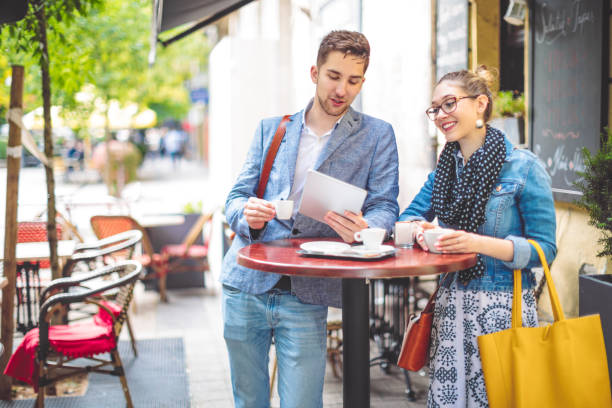 istock Friends are sharing a tablet in a sidewalk cafe 1021101618