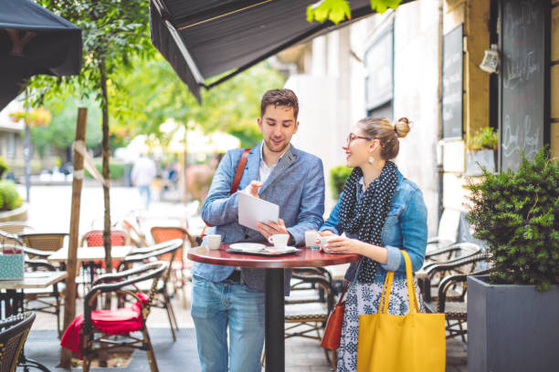istock Friends are sharing a tablet in a sidewalk cafe 1021101716