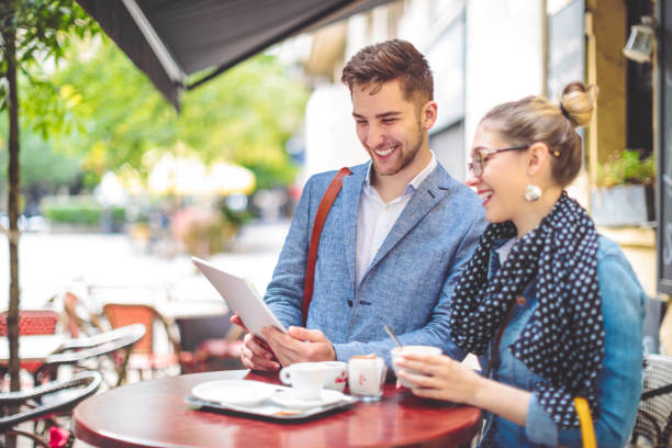 istock Friends are sharing a tablet in a sidewalk cafe 1021104372