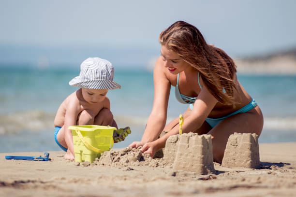 istock Beautiful mother and her little son playing on the beach 1021109896