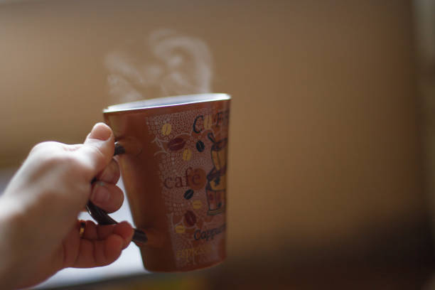 istock hot drink in a mug with steam in the hand 1021116494