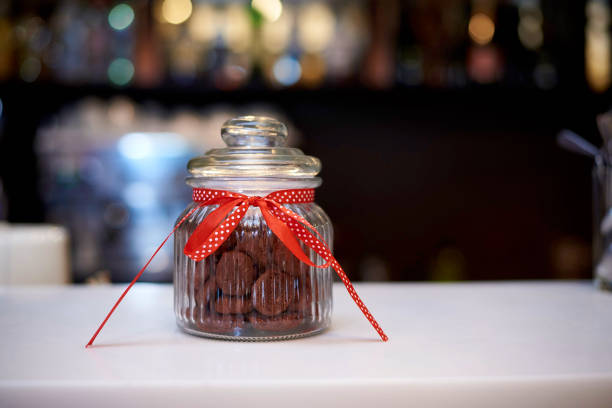 Glass jar with cookies on a dark background with bokeh.