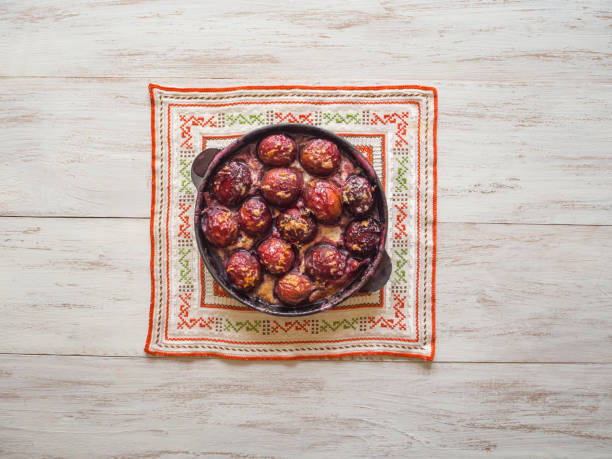 Baked plum in a frying pan. Rustic style.