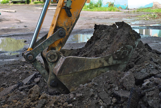istock Street roadway reconstruction - excavator removes old asphalt and does earthwork 1021129934