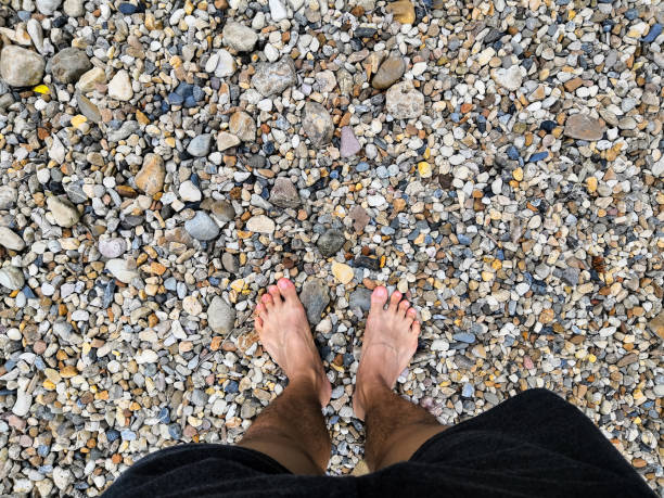 istock man's feet on little stone surface 1021133508