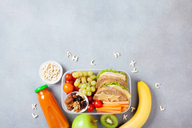 School lunch box with vegetables, fruits and sandwich on kitchen table top view. School lunch box with vegetables, fruits and sandwich on kitchen table top view. Copy space for text. food elementary student healthy eating schoolboy stock pictures, royalty-free photos & images
