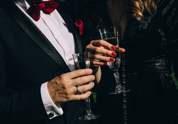 party champagne style black clothes red accessories party style man in black suit red butterfly woman in black clothes red manicure drink champagne tuxedo stock pictures, royalty-free photos & images
