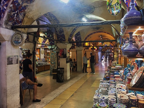 Grand Bazaar, Istanbul, Turkey - 31 July, 2018: Watching the colorful corridor of the historical bazaar by standing beside a poercelain and ceramic store.
