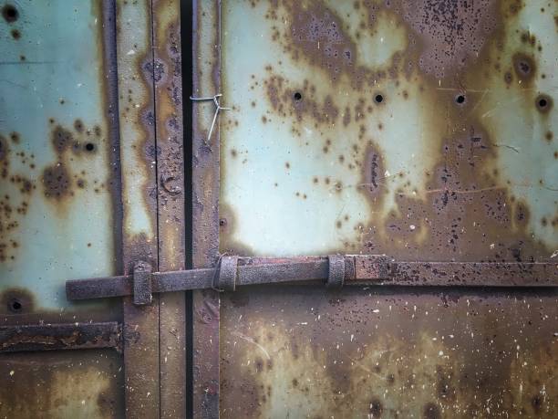istock Closed rusty metal door with lock, heart shaped door lock. 1021159832