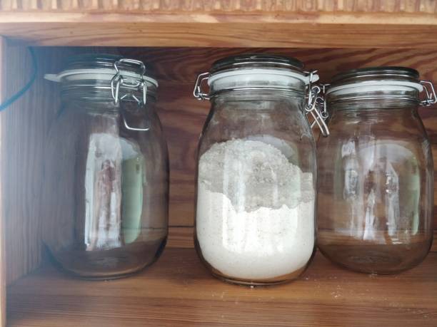 White fine flour in retro large glass jar on table