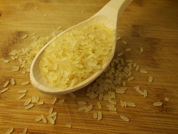 istock Parboiled long grain rice in wooden spoon, closeup 1021169384
