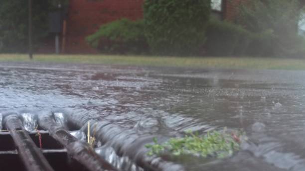 Heavy rain falling on the street and flowing through sewer drain During a heavy rain falling on the street and flowing through sewer drain heavy rainfall stock pictures, royalty-free photos & images