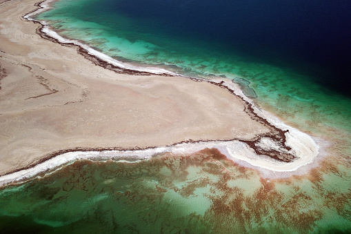 Aerial detail of the west shores of the Dead Sea in the vicinity of Ein Gedi, Israel. Visible features of receiding water levels and salt deposits due to extremely high salinity of the waters.