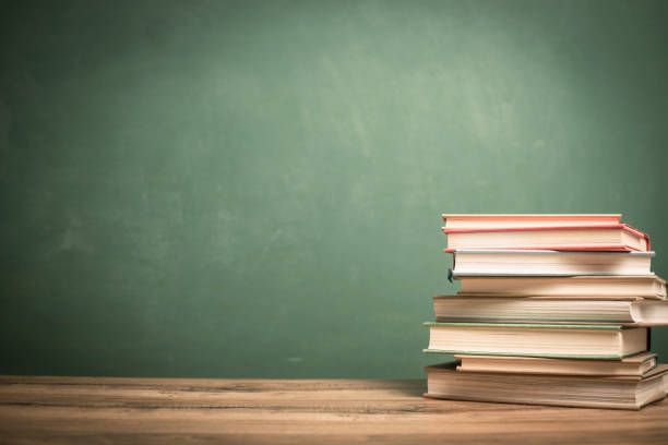 istock Textbooks on wooden school desk with chalkboard. 1021174686
