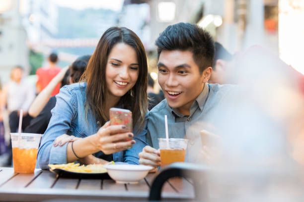 istock Young couple look at smartphone while at lunch 1021177974