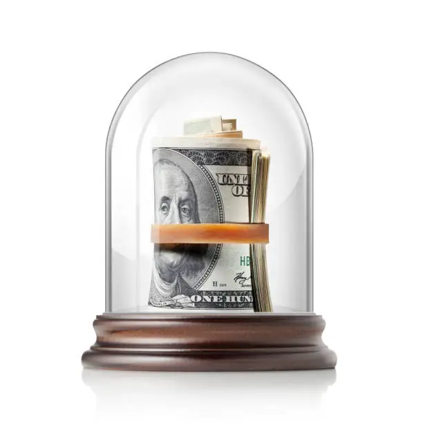Roll of dollar banknotes in glass bell jar on white background.