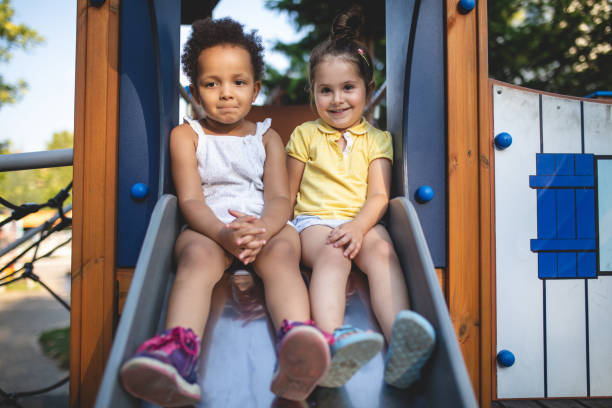 istock Smiling siblings sitting on a slide together 1021195028