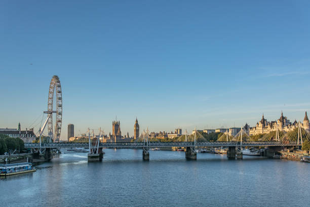 London breaking Dawn with the "London Eye" and the Hungerford Bridge and Golden Jubilee Bridges UK Image capture of central London at dawn highlighting the "London Eye" Ferris wheel and Hungerford Bridge and Golden Jubilee Bridges, UK tower bridge london england bridge europe stock pictures, royalty-free photos & images