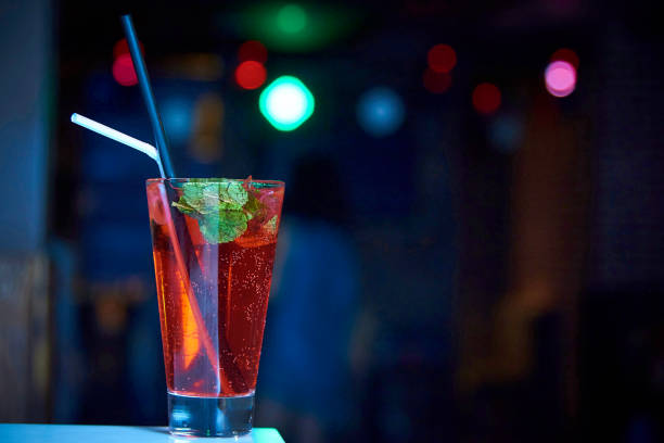 istock Bright cool cocktail with bubbles and straws on a dark background with bokeh. Copy space. 1021221410