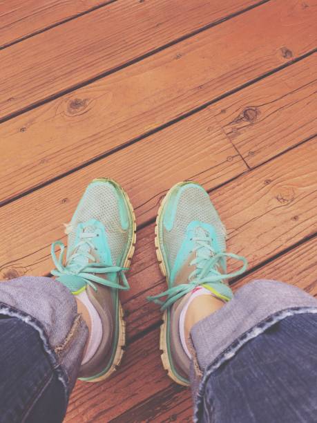 istock Feet in sneakers on a wood deck 1021223802