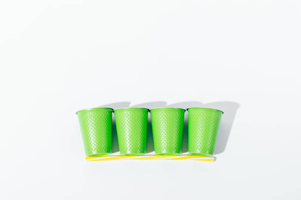Two glasses of Vodka with bottle on dark foggy club style background with glowing lights (Laser, Stobe) Multi colored. Club drinks theme decoration. Empty space. Selective focus