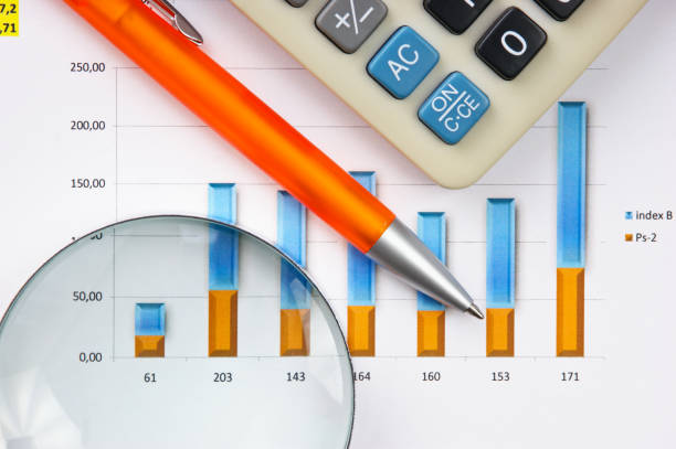 istock pen, magnifying glass and the working paper with a diagram 1021274468