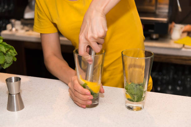 A barman girl is preparing a Mojito cocktail