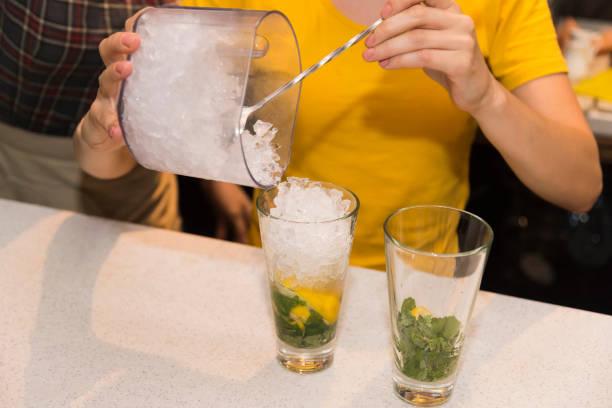 A barman girl is preparing a Mojito cocktail