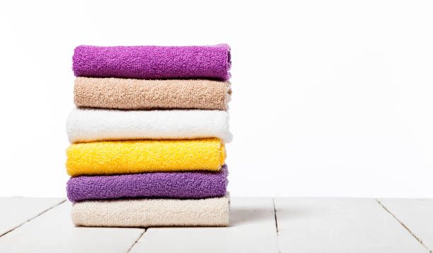 istock Stack of bath towels on light wooden table and white background 1021291130