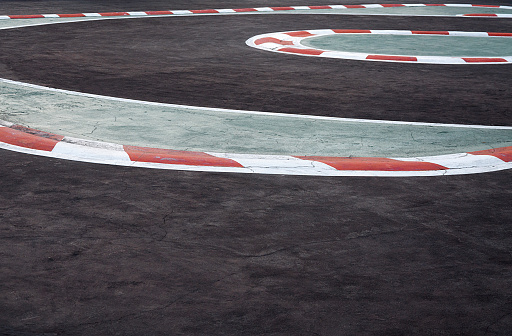 Curving asphalt red and white kerb of a race track detail,Motorsports racing circuit Race track curve road for car racing