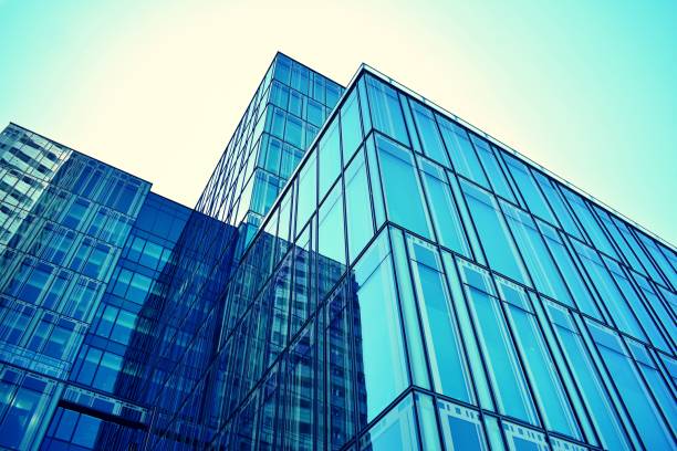 istock Modern office building on a clear sky background. Retro stylized colorful tonal filter effect 1021307502