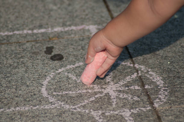 istock hand of child drawing with chalk on the floor 1021307596