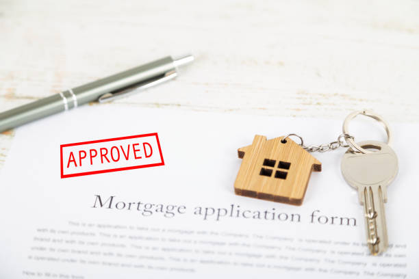 istock Approved mortgage loan agreement application with house shaped keyring 1021313444