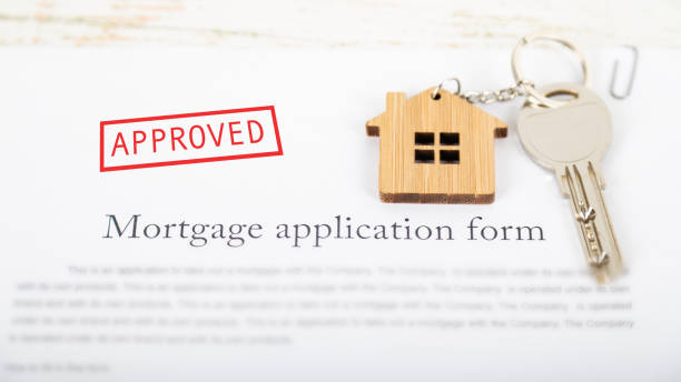 istock Approved mortgage loan agreement application with house shaped keyring 1021313448