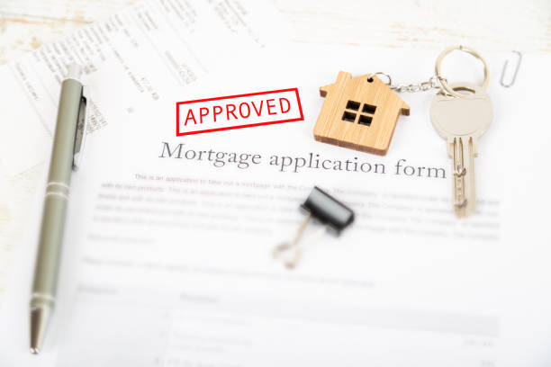 istock Approved mortgage loan agreement application with house shaped keyring 1021313450