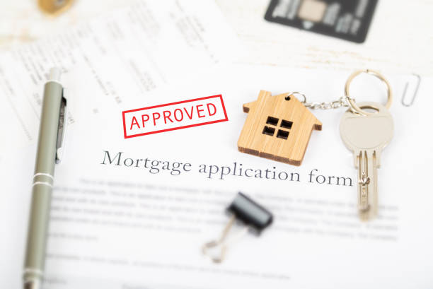 istock Approved mortgage loan agreement application with house shaped keyring 1021313456