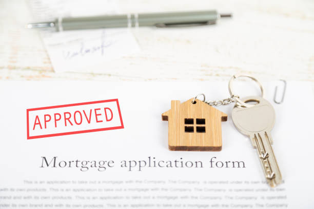 istock Approved mortgage loan agreement application with house shaped keyring 1021313482