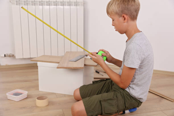 istock Boy sawing / working with wood a board in the carpentry 1021320880