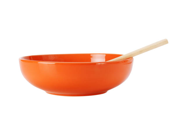 istock orange empty ceramic bowl and wooden spoon  isolated on white background 1021320966