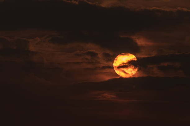istock Clouds in front of sun during sunset in orange 1021325214